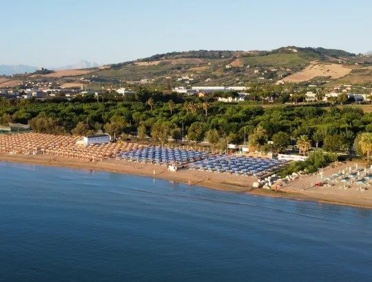 Spiaggia con ombrelloni e mare calmo.