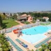Una piscina all'aperto con scivolo, lettini e palme.