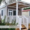 Una casa mobile con veranda e scale in legno bianco.