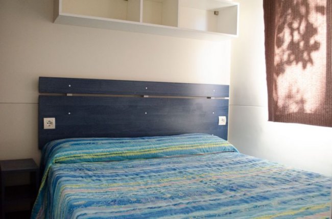 Camera da letto con letto matrimoniale e menzola.