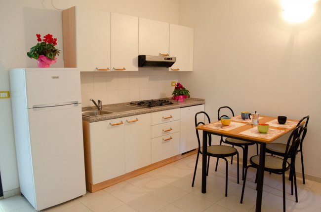 Cucina moderna con frigorifero bianco e tavolo da pranzo.