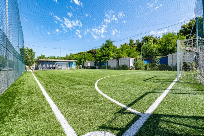 Un campo da calcetto con rete di protezione.