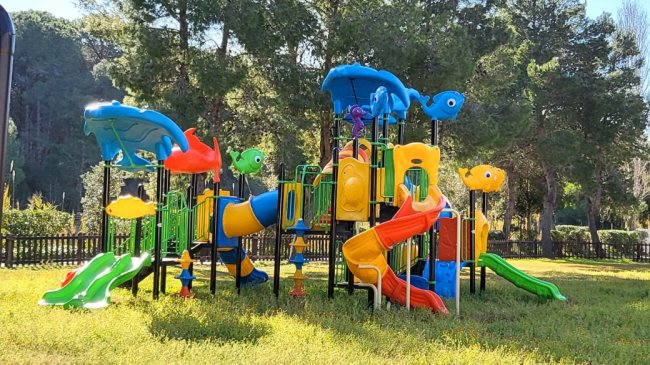 Un parco giochi colorato con scivoli e altalene.