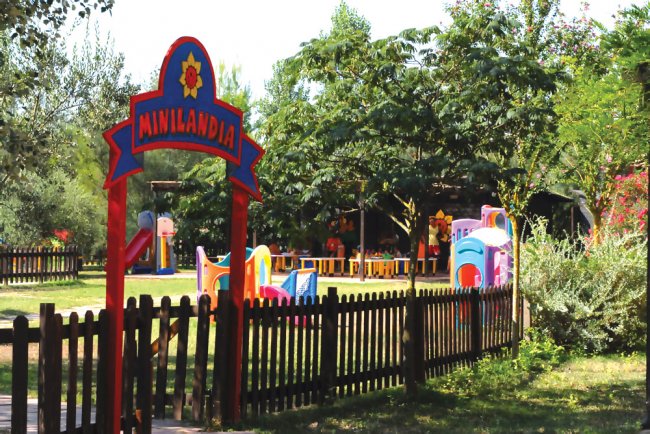 Parco giochi per bambini con recinto in legno e cartello