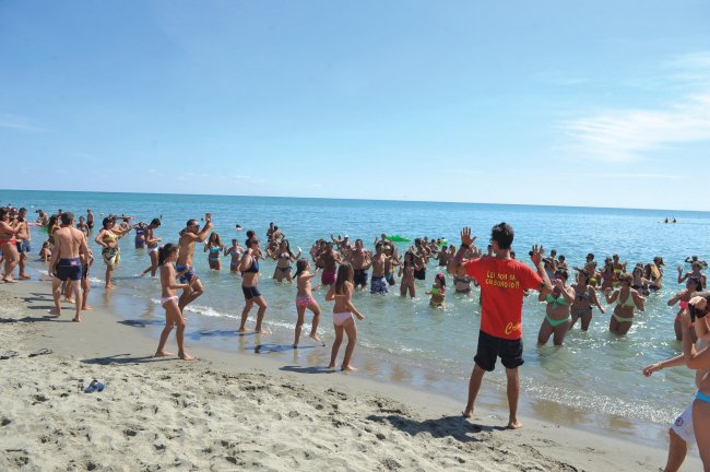 Persone fanno ginnastica sulla spiaggia.