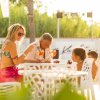 Famiglia seduta all'aperto con cocktail.