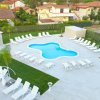 Piscina con sedie a sdraio bianche.