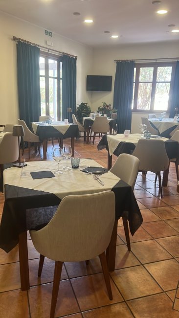 Sala ristorante con tavoli apparecchiati.