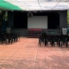 Un teatro all'aperto con sedie nere disposte davanti a un palco.
