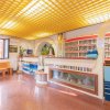 Una reception con soffitto giallo, piante e una scrivania decorativa.