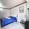Una camera semplice con letto matrimoniale, copriletto blu, scrivania bianca e poster di Calabria.