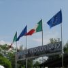 Insegna di un campeggio con bandiere europea e italiana.
