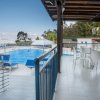 Terrazza con sedie bianche e piscina blu.
