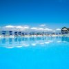 Vista della piscina con ombrelloni bianchi.