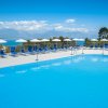 Piscina grande con lettini blu e vista mare.