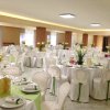Sala ricevimenti con tavoli rotondi elegantemente apparecchiati.