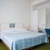 Camera da letto luminosa con letto matrimoniale e sedia blu.