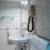 Bagno bianco con lavandino e asciugacapelli.
