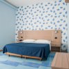 Camera da letto blu con fantasie geometriche sulle mura.