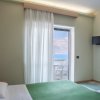 Camera con letto verde e vista mare dal balcone.