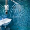 Bagno moderno con piastrelle blu e doccia in vetro.