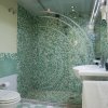 Bagno con piastrelle verdi, lavandino e wc.