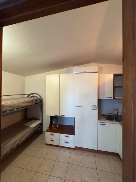 Stanza con letto a castello e armadietto bianco.