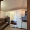 Stanza con letto a castello e armadietto bianco.