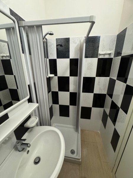 Bagno con cabina doccia e piastrelle a scacchi.
