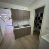 Cucina piccola con lavello e piano cottura, porta esterna.