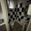 Bagno con piastrelle bianche e nere, lavabo e finestra.