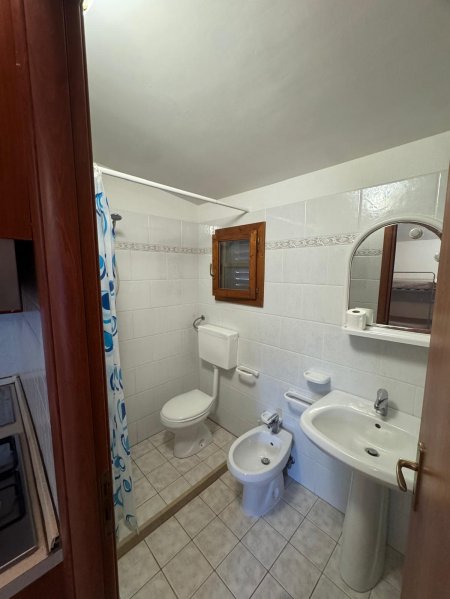 Bagno con doccia, wc, bidet e specchio sopra il lavabo.