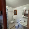 Bagno con doccia, wc, bidet e specchio sopra il lavabo.