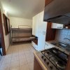 Cucina con fornelli, lavandino e letti a castello.