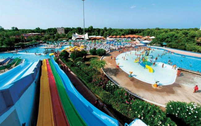 Parco acquatico con scivoli colorati e piscina.