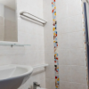 Bagno con lavabo, specchio, doccia e decorazioni colorate.