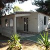 Una casa bianca con colonne e portico, circondata da alberi.