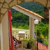 Arco in pietra con vista su terrazza e colline verdi.