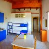 Interno di una cucina moderna con mobili blu, tavolo bianco e letto a castello.