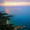 Panorama costiero al tramonto con mare e insenature.